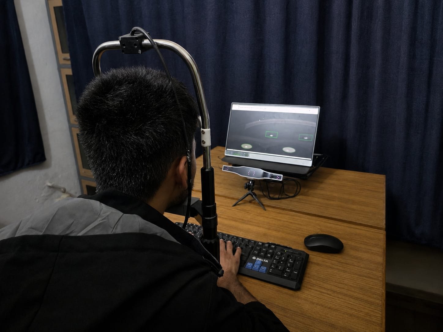 A participant using the laboratory eye-tracking apparatus while viewing stimuli on a monitor