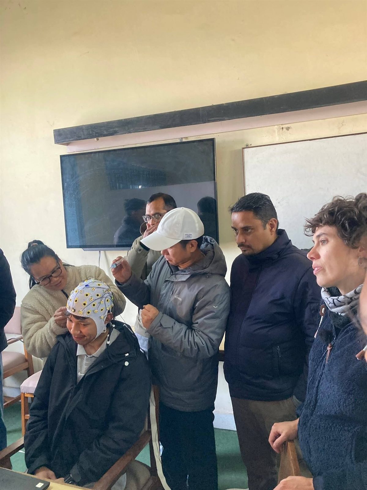 Participants fitting an EEG cap during the PsychoPy and EEG workshop at Tribhuvan University